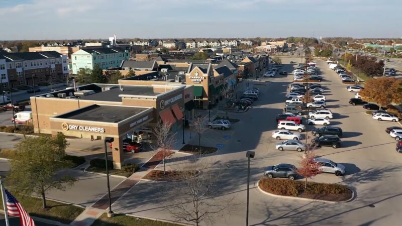 A Bustling Suburban Commercial Area in Naperville with A Variety of Shops and A Packed Parking Lot, Reflecting the Effects of Population Growth on Local Businesses