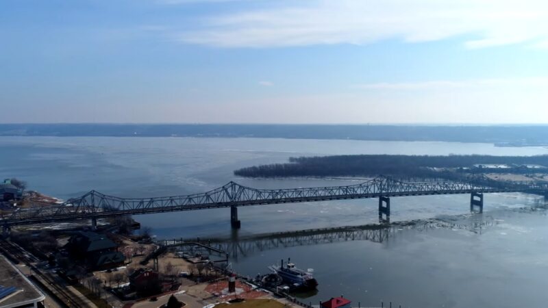 Aerial View of A Bridge Spanning a Partly Frozen River Near Peoria, with Industrial Buildings Nearby and A Distant View of A Wooded Island