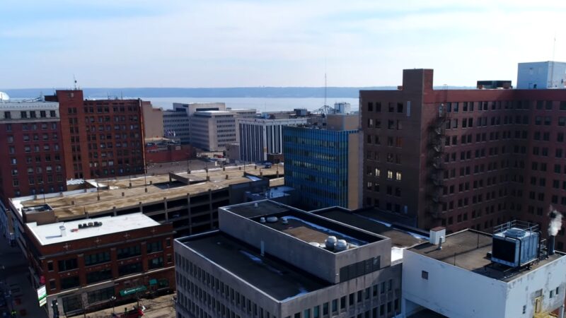 Aerial Shot of Downtown Peoria, Illinois, Highlighting Modern and Historical Buildings Against a Backdrop of The Distant River Horizon