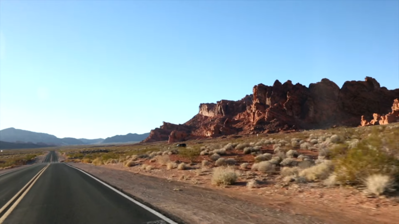 Desert Road on Route 66 with Striking Red Rock Formations Under a Clear Blue Sky, Showcasing the Beauty of The Journey in Warm Seasons