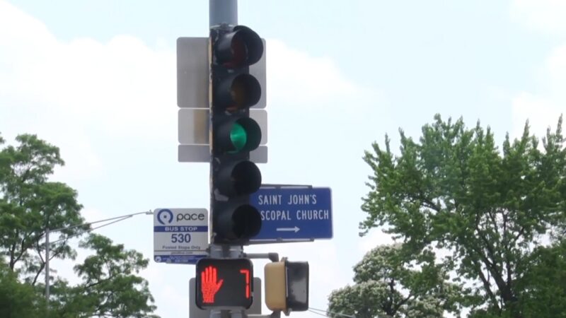 Traffic Light Showing a Green Signal Next to A Pedestrian Signal Displaying a Stop Hand and A Countdown, with A Sign for Saint John's Episcopal Church and A Bus Stop in Naperville